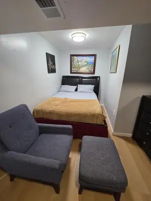 a bedroom with a bed and a chair at Newly renovated 1 room in a 3-bedroom apartment with private toilet ands bathroom in Irvington