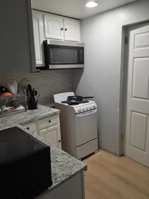 a kitchen with a stove and a microwave at Newly renovated 1 room in a 3-bedroom apartment with private toilet ands bathroom in Irvington
