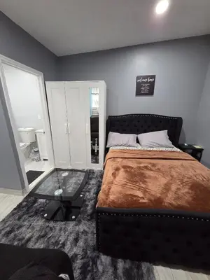 a bedroom with a bed and a glass table at Newly Built detached studio apartment with private toilet and bath in Irvington