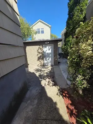 a garage with a door on the side of a house at Newly Built detached studio apartment with private toilet and bath in Irvington