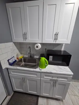 a kitchen with white cabinets and a sink at Newly Built detached studio apartment with private toilet and bath in Irvington