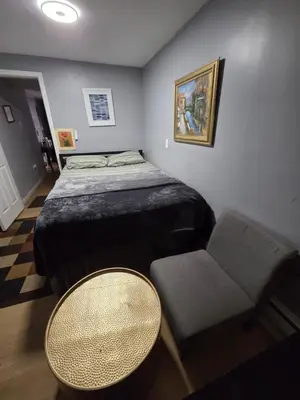 a bedroom with a bed and a table and a chair at Renovated Room with Private Bath in Ground Floor 3BR in Irvington