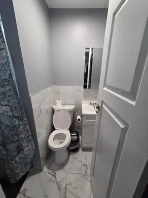 a white bathroom with a toilet and a sink at Renovated Room with Private Bath in Ground Floor 3BR in Irvington