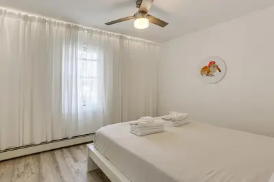 a white bedroom with a bed and a ceiling fan at Game Room and Hot Tub Family Gem on Lake Hopatcong