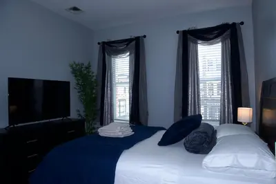 a bedroom with a bed with blue walls and windows at New York private room 29 in West New York