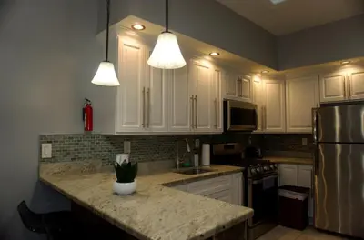 a kitchen with white cabinets and a granite counter top at New York private room 29 in West New York