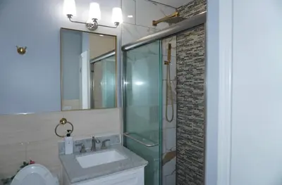 a bathroom with a sink and a glass shower at New York private room 29 in West New York
