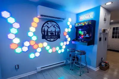 a room with a blue wall with a video game at Bear Trails Retreat-Pocono Getaway Near Kalahari in Pocono Summit