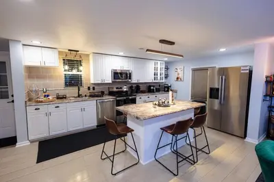 a kitchen with white cabinets and a island with bar stools at Bear Trails Retreat-Pocono Getaway Near Kalahari in Pocono Summit
