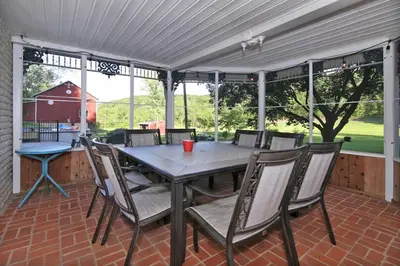 a patio with a table and chairs on a brick floor at Creekside Farmstead - Pool - Hot Tub - 3 Min to Lake - Pets Allowed in Auburn