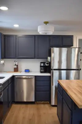 a kitchen with black cabinets and a stainless steel refrigerator at A-Frame Chalet Ski Lodge Near Shawnee in East Stroudsburg