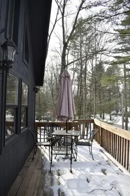 a table and chairs on a porch in the snow at A-Frame Chalet Ski Lodge Near Shawnee in East Stroudsburg