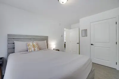 a white bedroom with a white bed and a white door at The Aerie House in Blakeslee