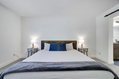 a bedroom with a large white bed with blue pillows at The Aerie House in Blakeslee