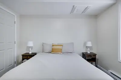 a bedroom with a large white bed with two night stands at The Aerie House in Blakeslee