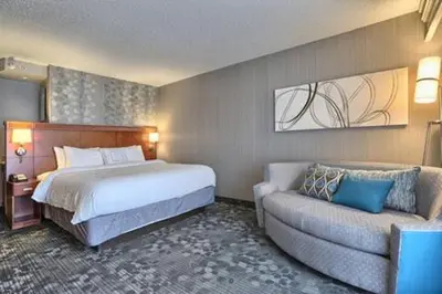 a hotel room with a bed and a couch at Courtyard by Marriott Harrisburg West Mechanicsburg in Mechanicsburg