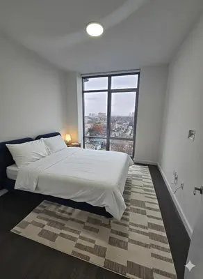 a bedroom with a large bed with a large window at Gorgeous View 1 BR 1 Bth 15 Min from NYC - Metlife in Cliffside Park