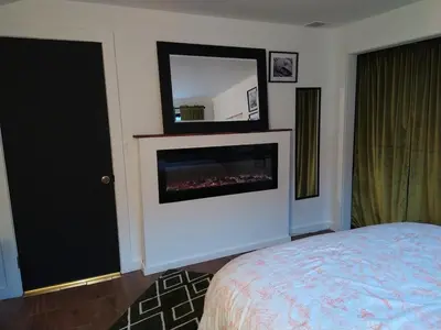 a bedroom with a fireplace and a bed and a mirror at Black Top Retreat in Wyalusing