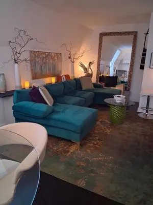 a living room with a blue couch and a mirror at Black Top Retreat in Wyalusing