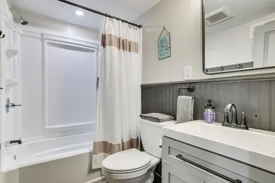 a bathroom with a toilet and a sink and a mirror at Poconos Ski Base with Hot Tub and Game Room! in Lake Harmony