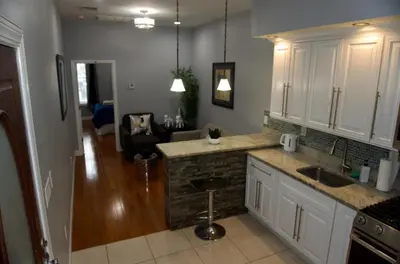 a kitchen with white cabinets and a counter top at New York Private room 30 in West New York