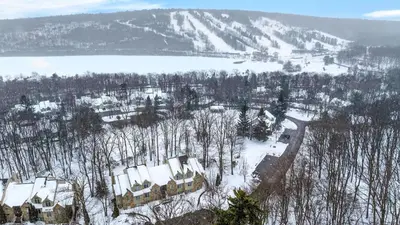 an aerial view of a house in the snow at Crestline Retreat by AvantStay Luxury Mountain Condo with Hot Tub BBQ Game Room Steps to Big Boulder in Lake Harmony