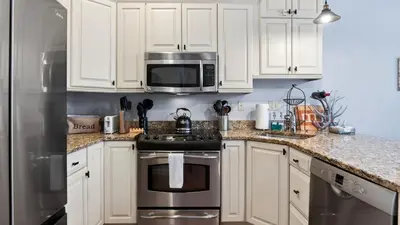 a kitchen with white cabinets and stainless steel appliances at Crestline Retreat by AvantStay Luxury Mountain Condo with Hot Tub BBQ Game Room Steps to Big Boulder in Lake Harmony