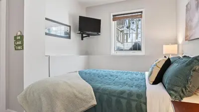 a bedroom with a bed and a tv on the wall at Crestline Retreat by AvantStay Luxury Mountain Condo with Hot Tub BBQ Game Room Steps to Big Boulder in Lake Harmony