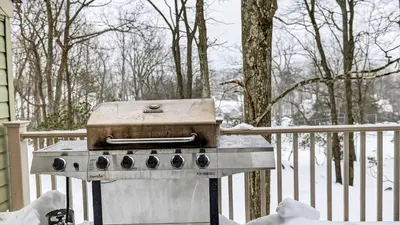a grill sitting on a porch in the snow at Crestline Retreat by AvantStay Luxury Mountain Condo with Hot Tub BBQ Game Room Steps to Big Boulder in Lake Harmony