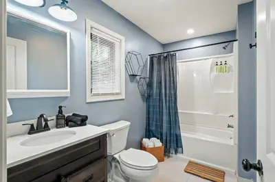 a bathroom with a sink and a toilet and a shower at Luxury Pocono Escape ~ Sauna | Hot Tub | Mini Golf in Tobyhanna