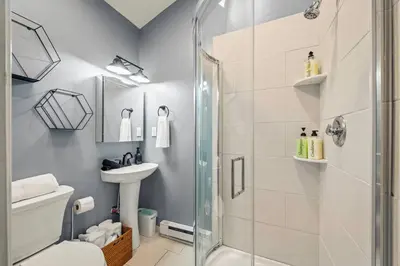 a bathroom with a shower and a toilet and a sink at Luxury Pocono Escape ~ Sauna | Hot Tub | Mini Golf in Tobyhanna