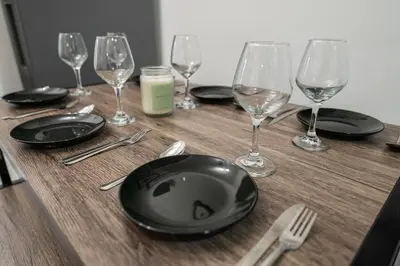 a table with black plates and wine glasses on it at Modern 3 Bedroom 7 minutes to Manhattan in Jersey City