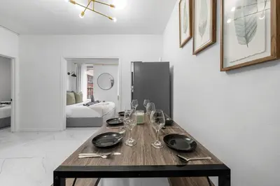 a dining room table with glasses and plates on it at Modern 3 Bedroom 7 minutes to Manhattan in Jersey City