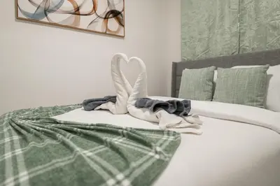 a bedroom with a bed with towels on it at Modern 3 Bedroom 7 minutes to Manhattan in Jersey City