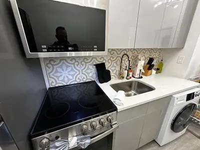a kitchen with a stove and a sink and a microwave at JC Central Stylish Stay Near Manhattan 1A in Jersey City
