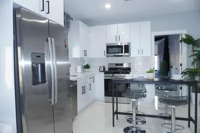 a kitchen with white cabinets and a stainless steel refrigerator at Big apple room 35 in West New York
