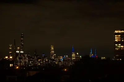 a city skyline at night with blue lights at Big apple room 35 in West New York