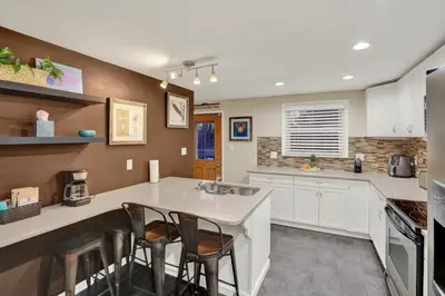 a kitchen with a sink and a counter with stools at Cozy 1 bedroom house in Lititz in Lititz