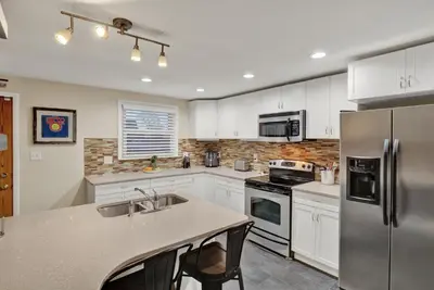 a kitchen with white cabinets and a stainless steel refrigerator at Cozy 1 bedroom house in Lititz in Lititz
