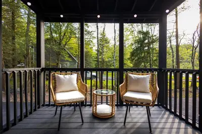 two chairs and a table on a screened in porch at Deer Trails Retreat -Pocono Getaway Near Kalahari in Pocono Summit