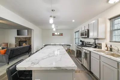 a kitchen and living room with a large marble counter top at The Aerie House In Tobyhanna in Tobyhanna