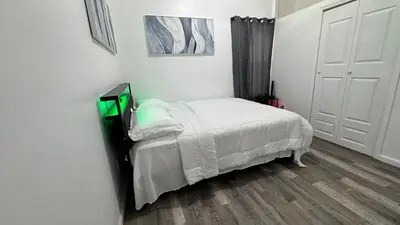 a small white bedroom with a bed and a door at Style and tranquility within walking distance of everything