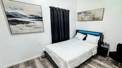 a bedroom with a bed and a painting on the wall at Style and tranquility within walking distance of everything