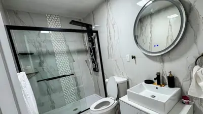 a bathroom with a shower and a toilet and a sink at Style and tranquility within walking distance of everything