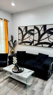 a living room with a black couch and a table at Style and tranquility within walking distance of everything