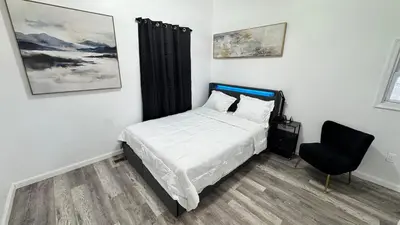 a bedroom with a bed and a chair at Style and tranquility within walking distance of everything