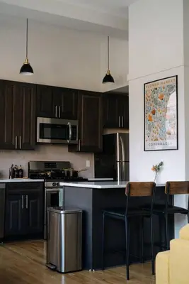 a kitchen with black cabinets and a counter top at 2BR City Getaway - Close to NYC - Prime Location in Hoboken