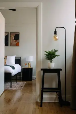 a bedroom with a bed and a table with a plant on it at 2BR City Getaway - Close to NYC - Prime Location in Hoboken