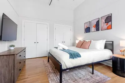 a bedroom with a bed and a flat screen tv at 2BR City Getaway - Close to NYC - Prime Location in Hoboken