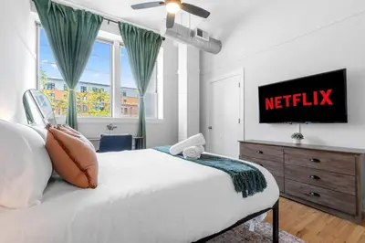 a bedroom with a bed and a television on a dresser at 2BR City Getaway - Close to NYC - Prime Location in Hoboken